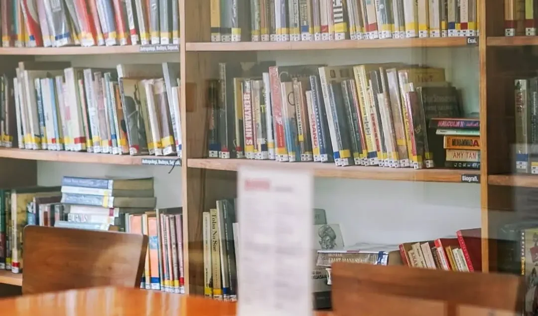 rak buku dan meja baca di cafe berkonsep perpustakaan mini